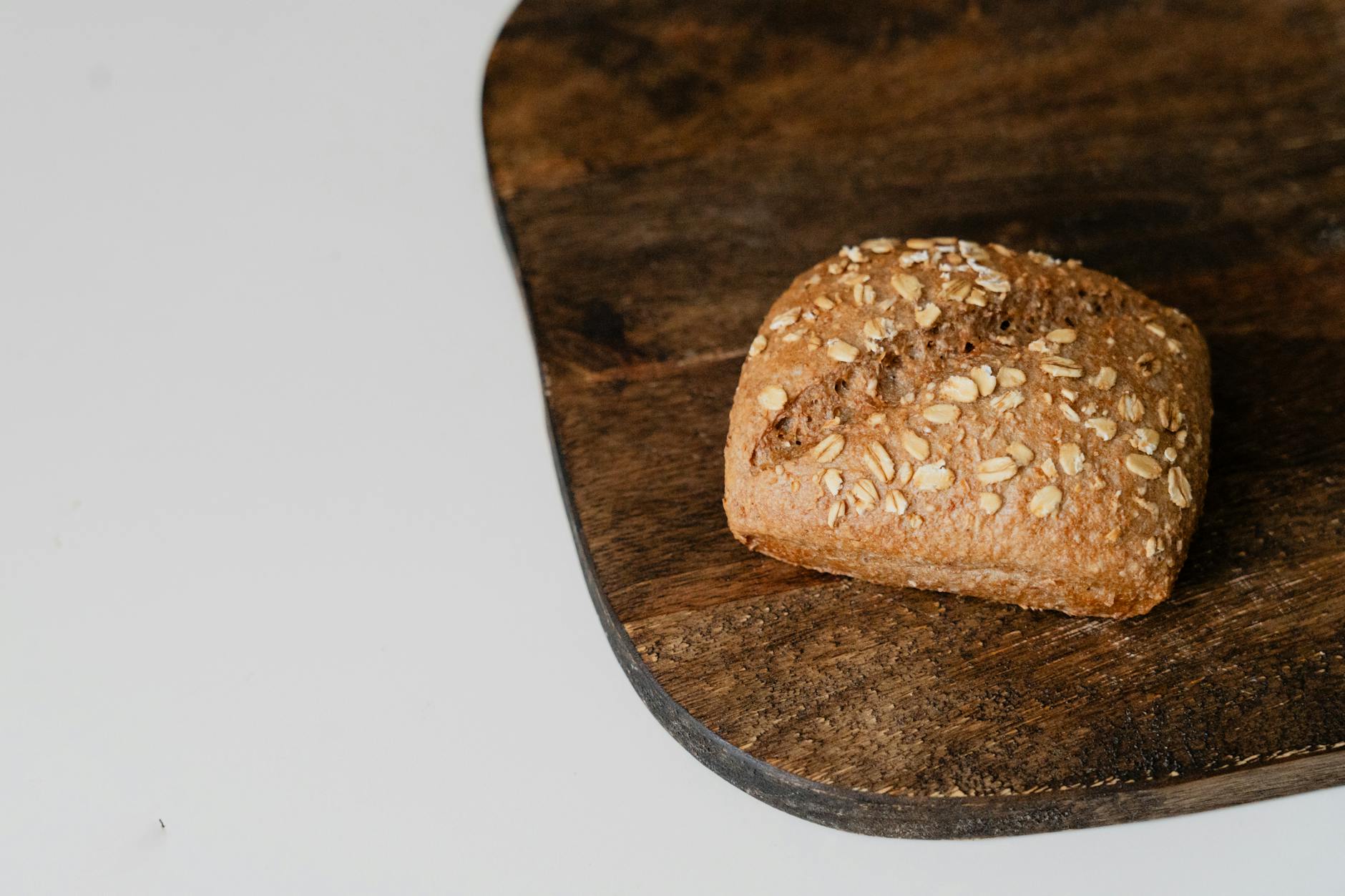 Bułka z pełnego ziarna z płatkami owsianymi na drewnianej desce