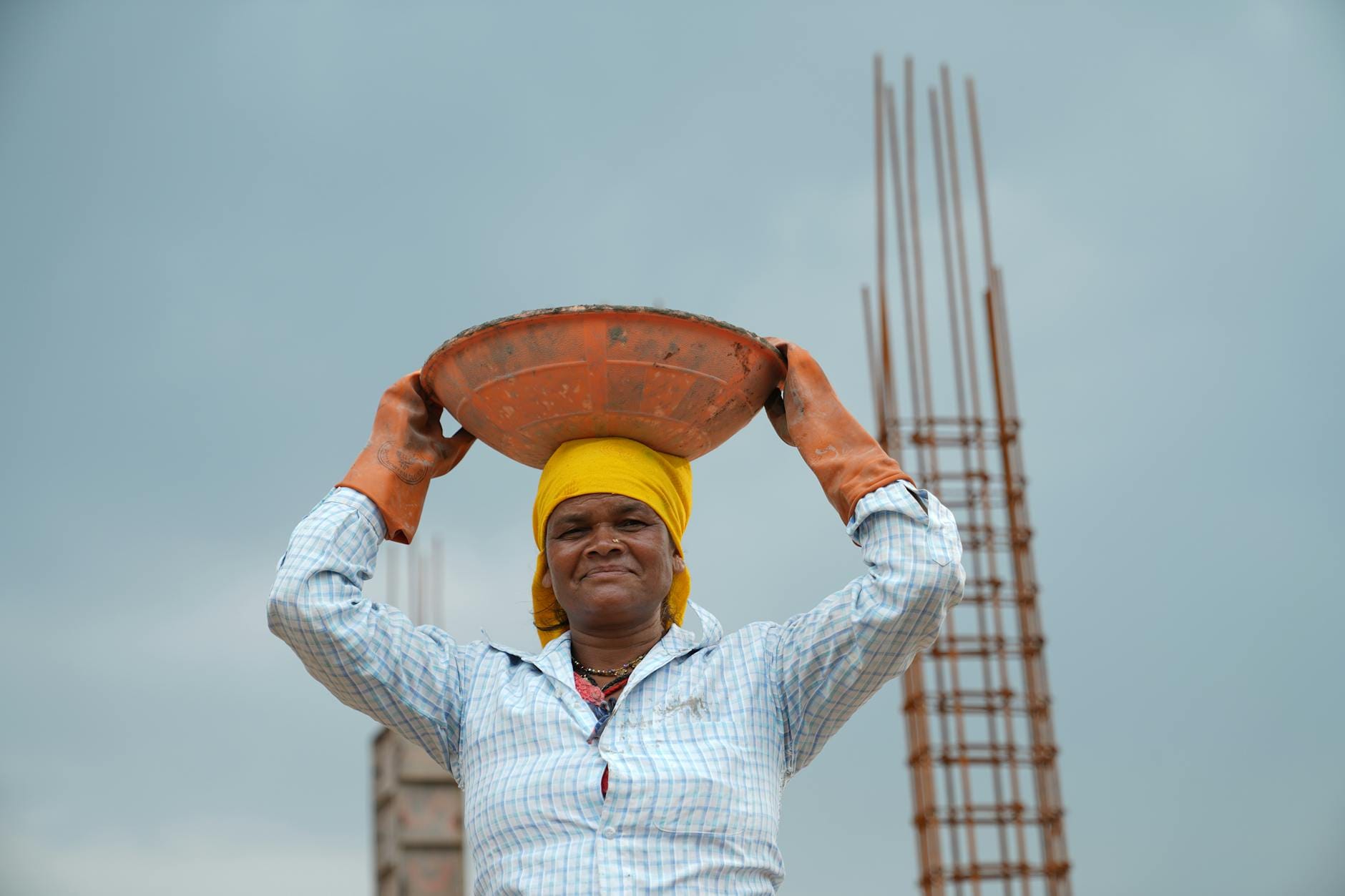 Kobieta na budowie niesie miskę z materiałami, wysiłek fizyczny