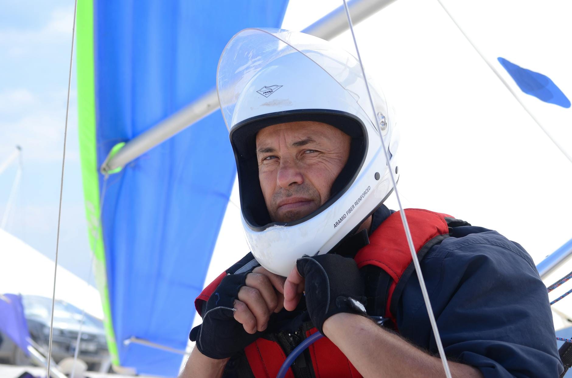 Żeglarz w kasku i kamizelce asekuracyjnej szykuje się do rejsu