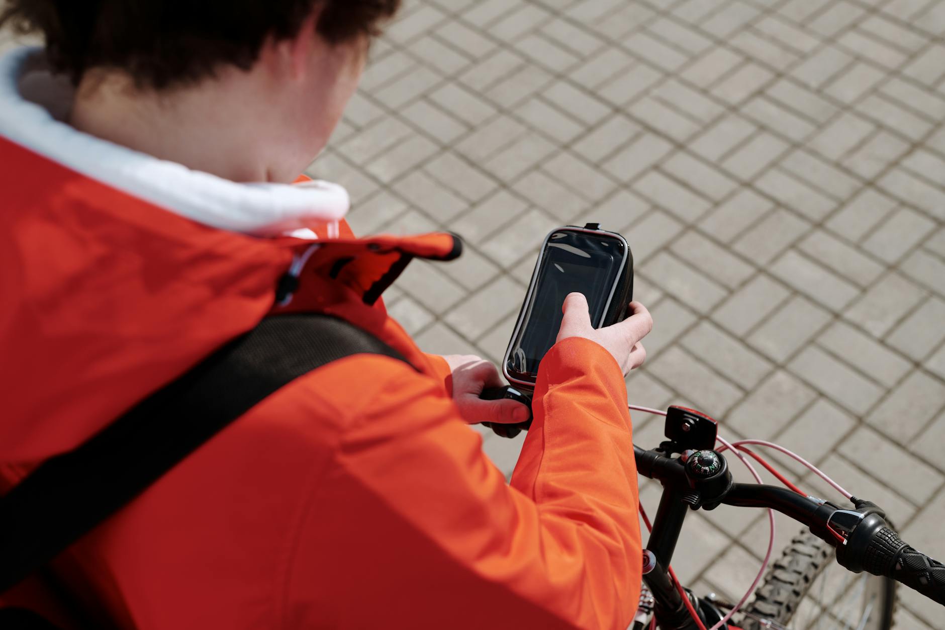 Rowerzysta w mieście korzysta ze smartfona zamocowanego na kierownicy