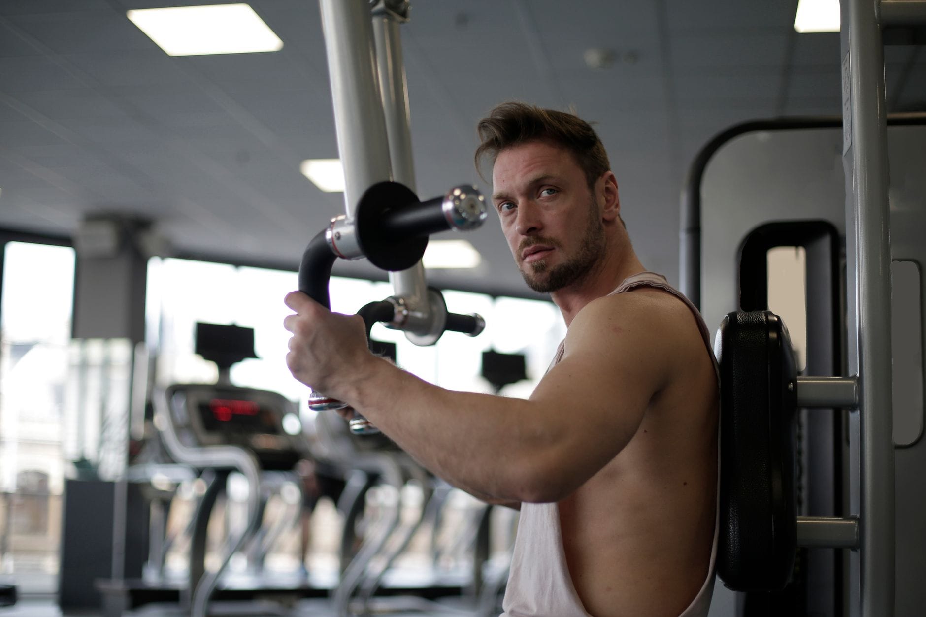 Skupiony mężczyzna ćwiczy biceps na siłowni podczas treningu