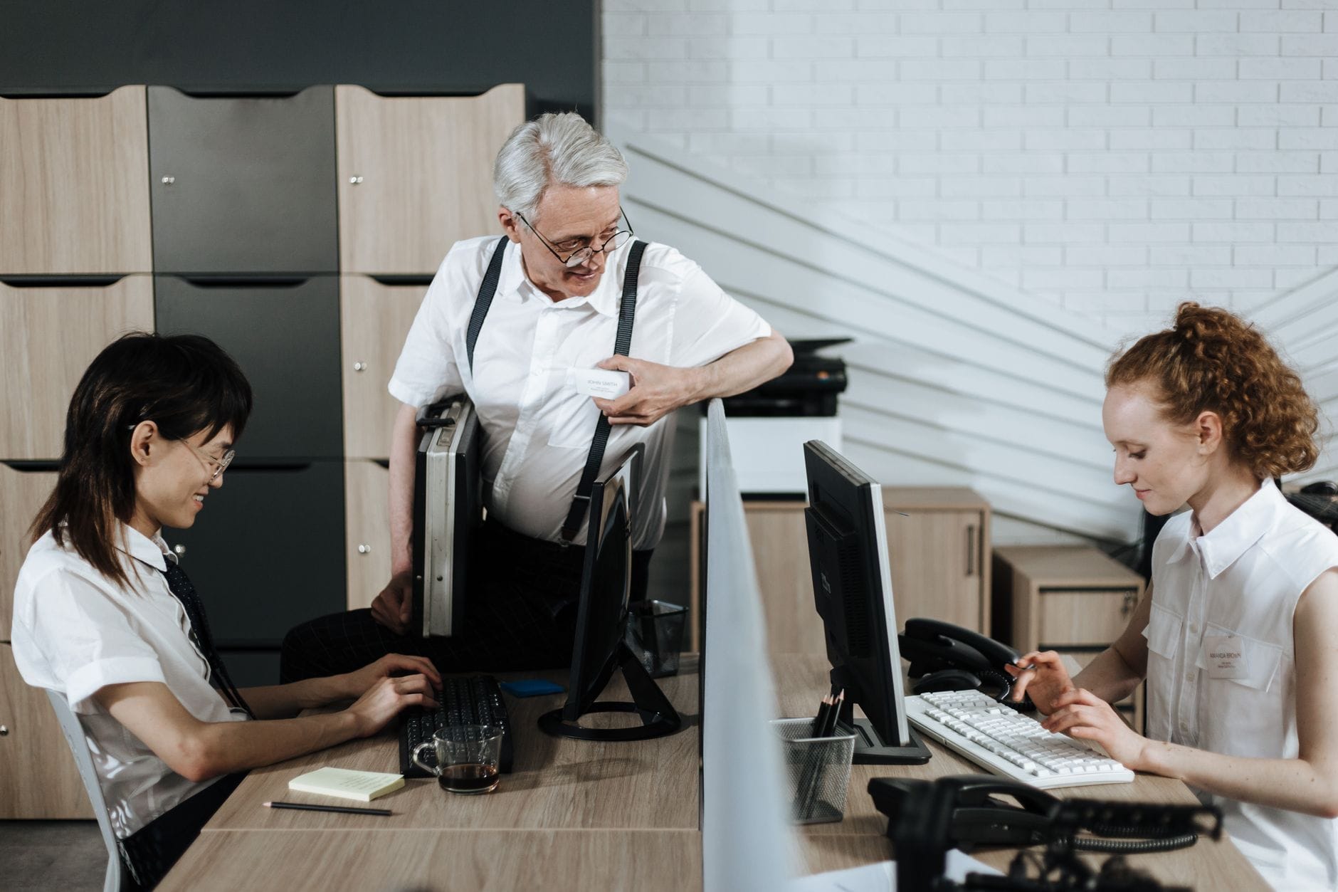 Pracownicy biurowi siedzą przy biurkach i współpracują w open space